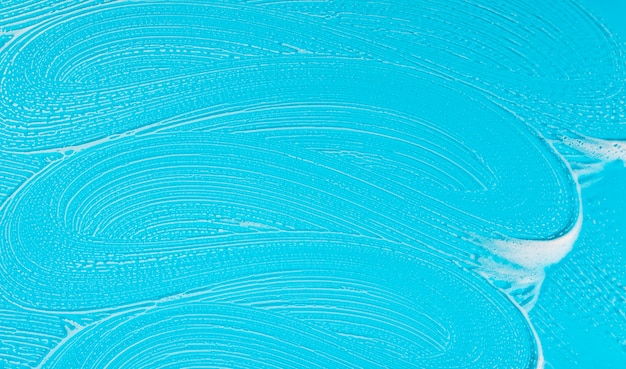 Espuma de sabão plana leigos sobre fundo azul