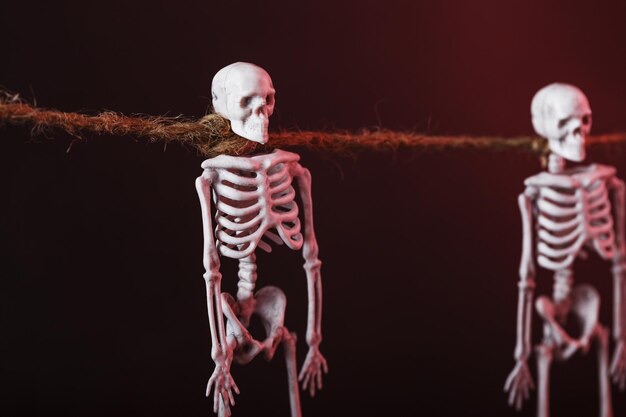 Esqueletos decorativos pendurados em uma corda em um fundo sombrio. decoração de halloween