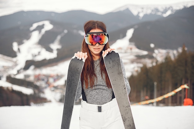 Esqui morena jovem e ativa. mulher nas montanhas nevadas.