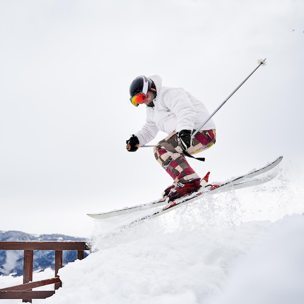 Esquiador masculino esquiando em declive através de neve em pó profunda