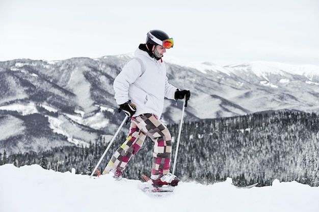 Esquiador usando equipamento de esqui passando tempo nas encostas das montanhas na temporada de inverno