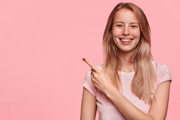 Esse é o seu lugar! Mulher europeia bonita com sorriso positivo no rosto