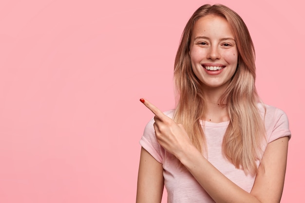Esse é o seu lugar! Mulher europeia bonita com sorriso positivo no rosto