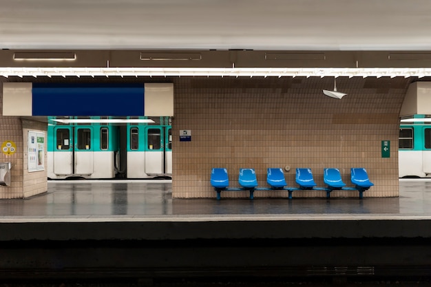 Estação de metrô com trem e assentos do metrô