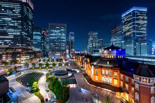 Estação ferroviária de Tóquio e edifício do distrito financeiro à noite, Japão.