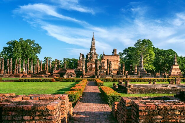 Estátua de Buda e templo Wat Mahathat no recinto do Parque Histórico de Sukhothai