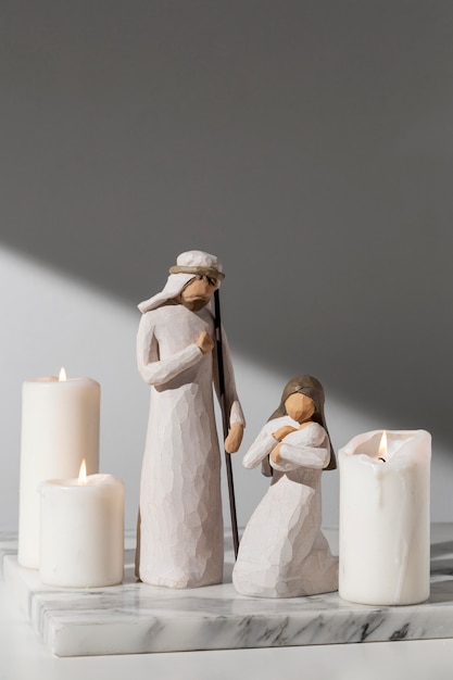 Foto grátis estatueta feminina e masculina do dia da epifania com recém-nascido e velas