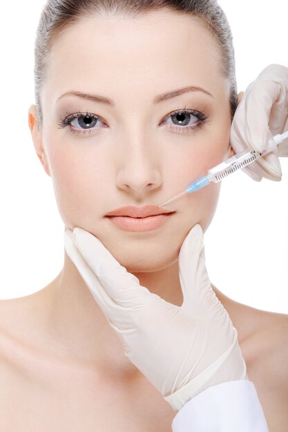 Esteticista aplicando injeção de botox nos lábios femininos