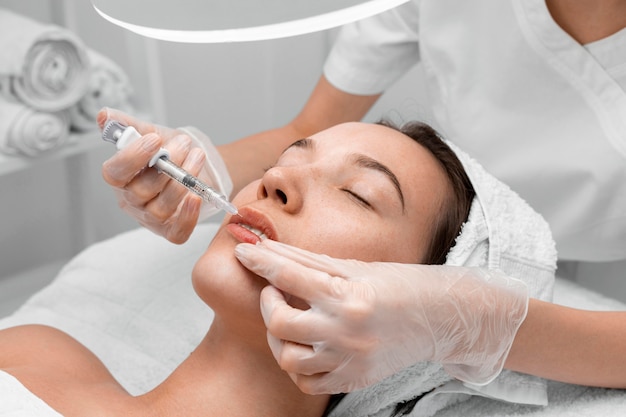 Esteticista aplicando preenchimento com injeção em cliente