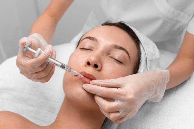 Esteticista aplicando preenchimento com injeção em cliente