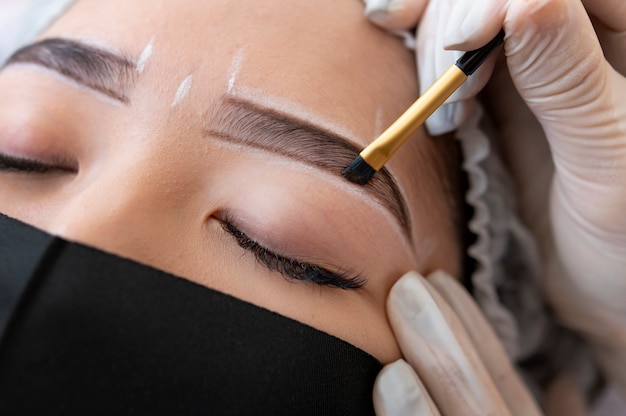 Foto grátis esteticista fazendo um tratamento de microblading nas sobrancelhas de uma cliente
