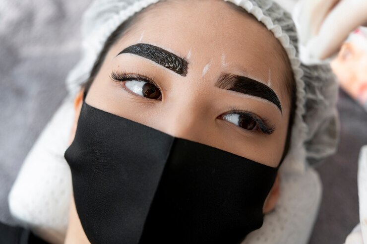 Foto grátis esteticista fazendo um tratamento de microblading nas sobrancelhas de uma cliente