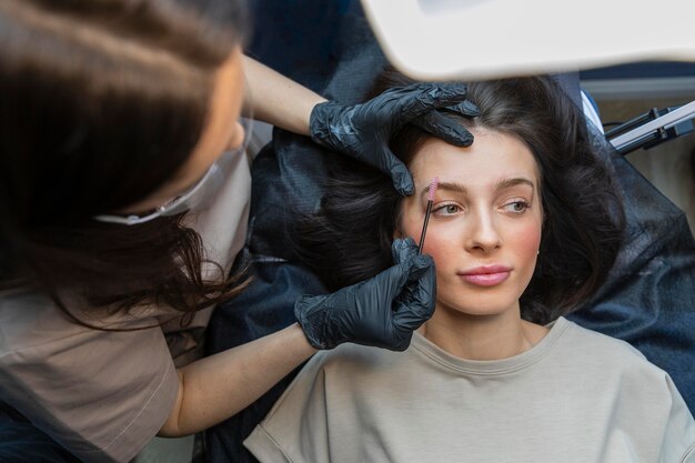 Esteticista fazendo um tratamento de sobrancelha para seu cliente