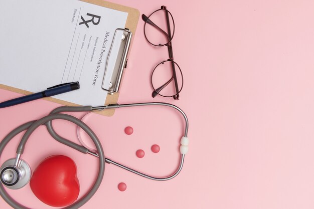 Estetoscópio com coração. Estetoscópio e coração vermelho na mesa de madeira. Conceito de seguro de vida em hospital. Ideia do dia mundial da saúde do coração. Conceito de medicamento ou farmácia. Formulário médico vazio pronto para ser usado.