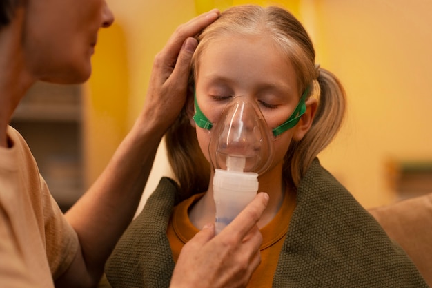 Foto grátis estilo de vida da menina com inalação com um nebulizador