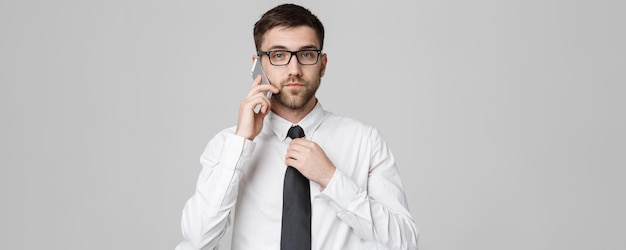 Estilo de vida e conceito de negócios Retrato de um empresário bonito falando sério com telefone celular Fundo branco isolado Espaço para cópia