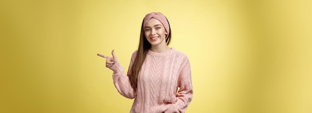 Foto grátis estilo de vida pessoas apontando conceito jovem atraente com cabelo comprido e reto vestindo suéter