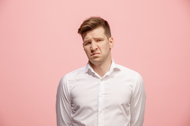 Estou cansado de tudo. Homem triste. Conceito chato, sem graça e tedioso. Jovem emocional. Emoções humanas, conceito de expressão facial. Estúdio isolado no espaço rosa na moda.