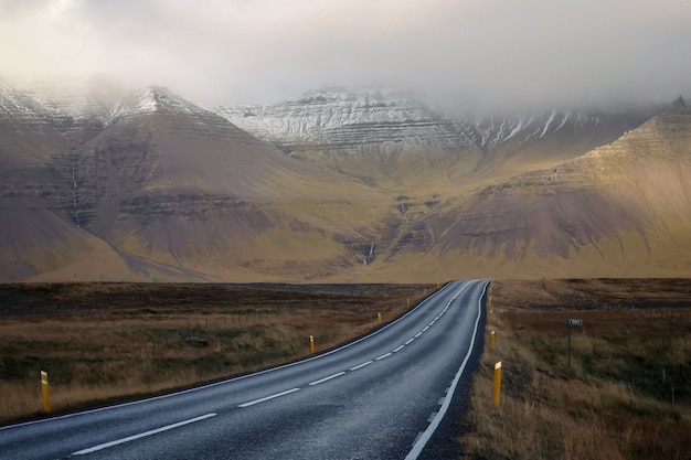 Estrada longa e estreita, com belas colinas e montanhas cobertas de nevoeiro