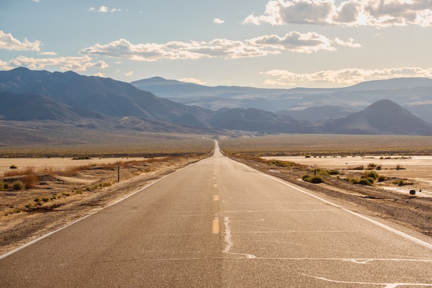 Estrada no meio do deserto com as magníficas montanhas da Califórnia