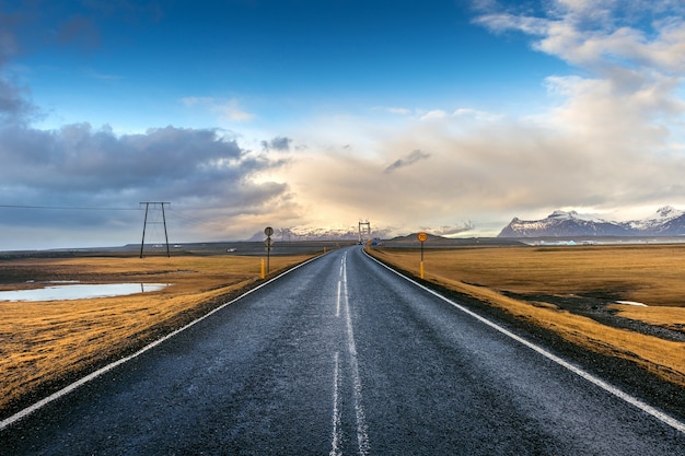 estrada reta longa e céu azul, Islândia.