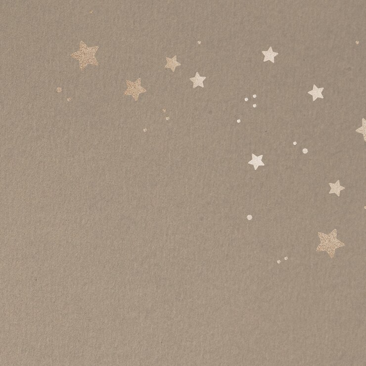 Foto grátis estrelas douradas cintilantes em um fundo bege