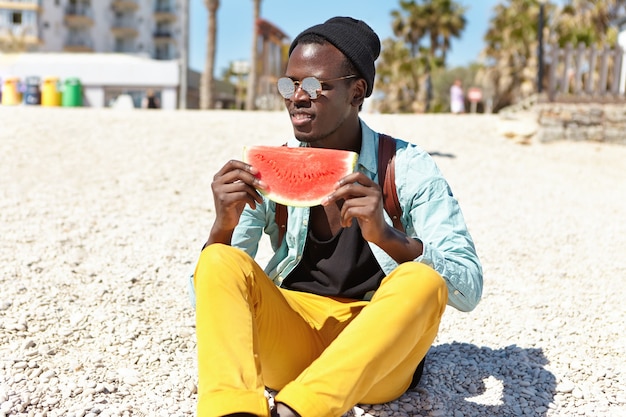 Estudante atraente relaxando depois da universidade em uma praia urbana