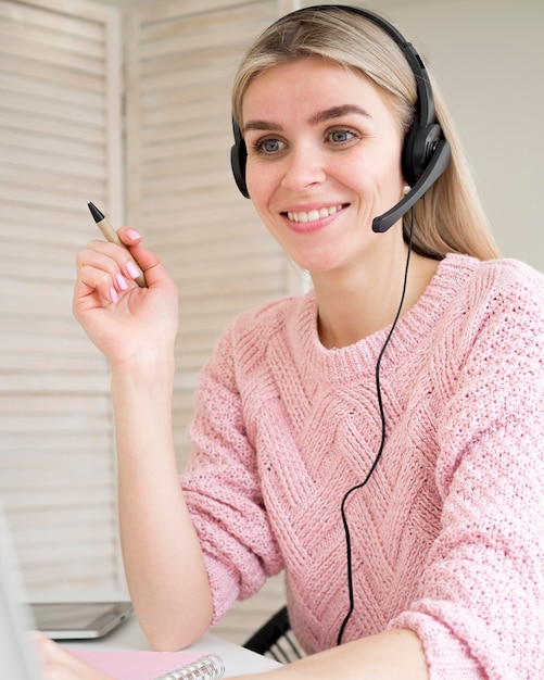 Foto grátis estudante bonito sorridente usando fones de ouvido conceito de aprendizagem