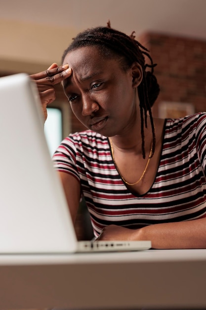 Estudante cansado estressado com enxaqueca, olhando para a tela do laptop, sofrendo de sintoma de dor de cabeça, esfregando a testa. Trabalhador remoto exausto se sentindo mal, trabalhando freelancer infeliz