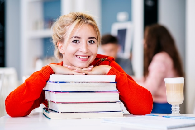 Estudante, com, pilha livros, ligado, tabela