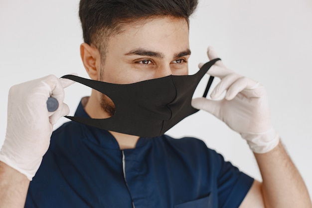 Estudante de medicina internacional. Homem de uniforme azul. Doutor com máscara.