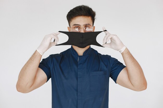 Estudante de medicina internacional. Homem de uniforme azul. Doutor com máscara.