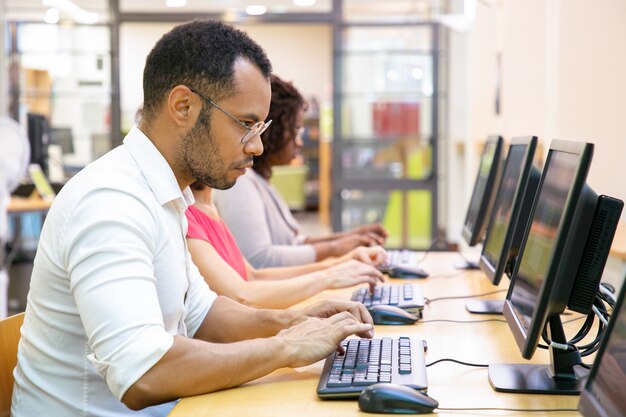 Estudante do sexo masculino extremamente focado fazendo teste on-line