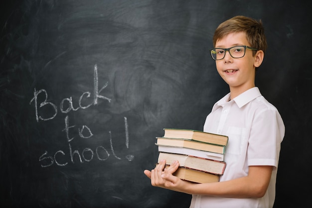 Estudante em camisa branca segurando livros