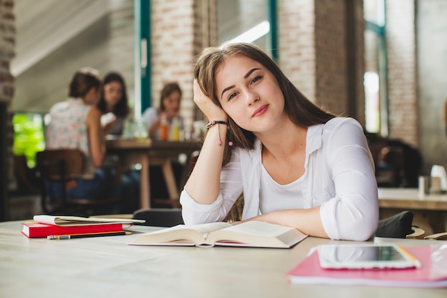 Estudante encantador posando com livro de texto