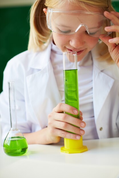 Estudante esperto segurando um tubo com líquido verde