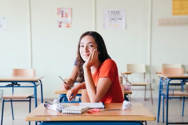 Estudante feliz posando na sala de aula