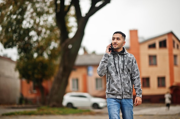 Foto grátis estudante kuwaitiano usa capuz falando por telefone