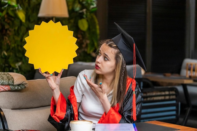 Estudante pensativo segurando o quadro de ideias e olhando para ele