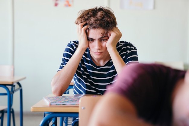 Estudante preocupado na sala de aula