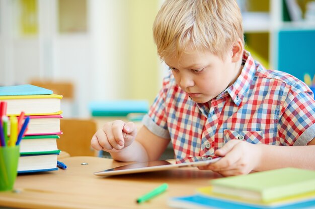 estudante primário inteligente com uma tabuleta digital