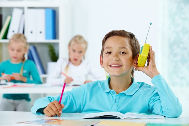 Estudante que escuta a música na sala de aula