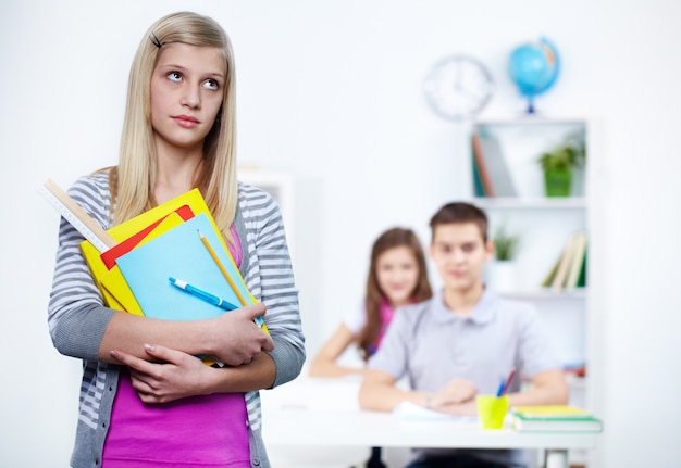 Estudante que prende seus materiais escolares