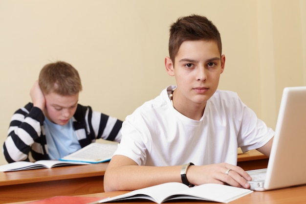 Estudante que usa um computador em sala de aula