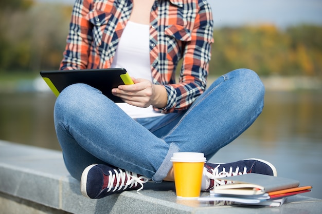 Estudante sentado turco na ponte com tablet