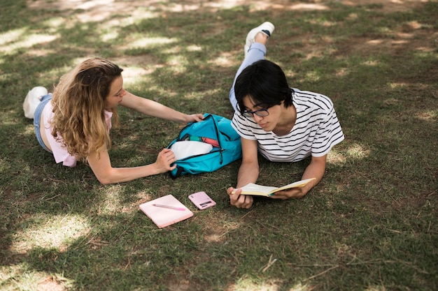 Estudantes adolescentes casuais no prado verde no parque