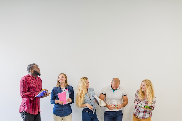 Foto grátis estudantes com livros posando e falando