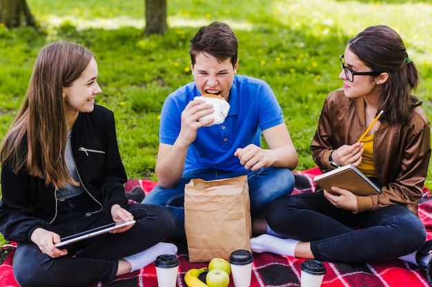 Foto grátis estudantes comendo e estudando