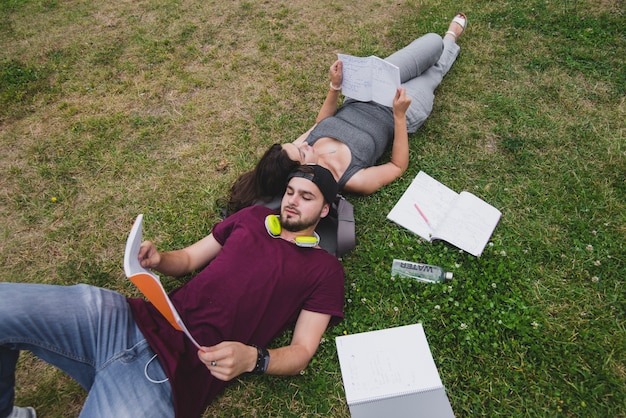 Estudantes deitado na grama lendo