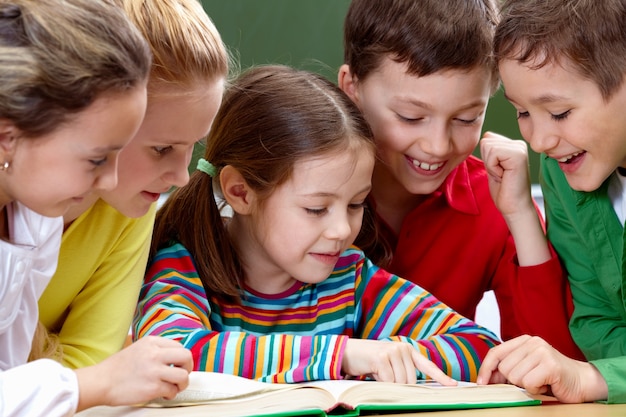 Estudantes que têm um bom tempo durante a leitura em sala de aula